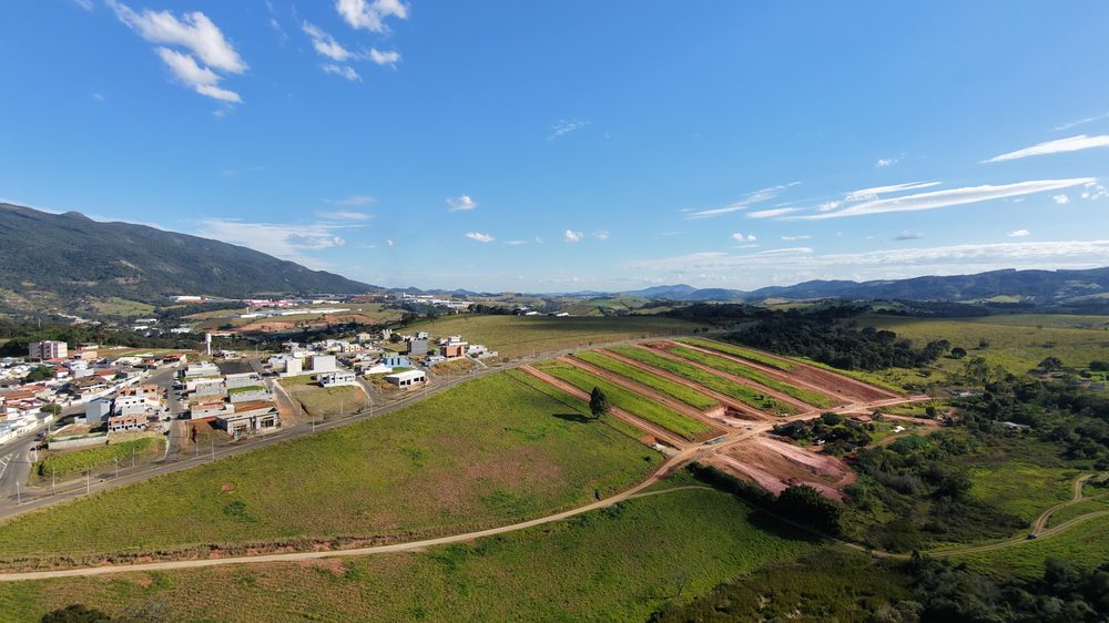 Vista aérea completa do Recanto dos Lagos, com a cidade de Extrema e a serra ao fundo