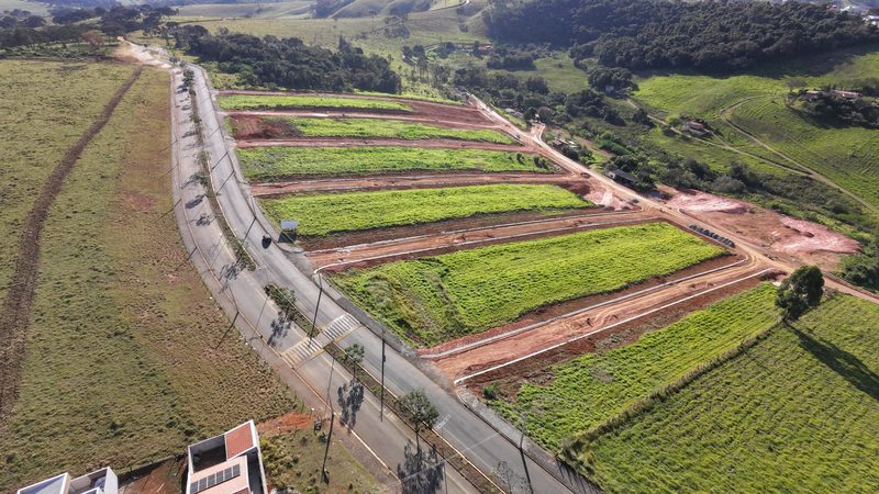 Avenida de acesso já pavimentada, com faixa de pedestres e quadras ao lado