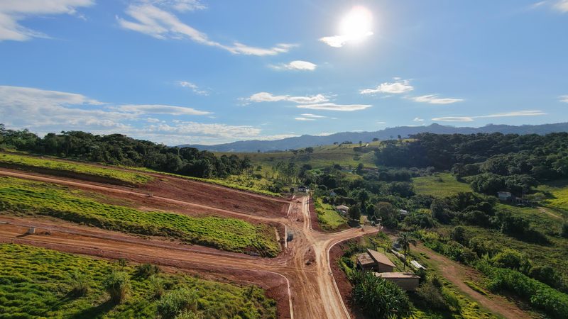 Via de acesso em fase final de terraplenagem, cercada por área rural