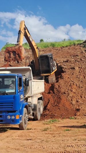 Escavadeira carregando caminhão basculante durante a terraplenagem